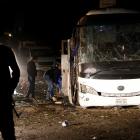 Police officers inspect a scene of a bus blast in Giza. Photo: Reuters