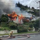 Fire crews work to put out a fire that destroyed a Reed St, Oamaru, home and set alight a neighbouring property yesterday. Photo: Logan Harris