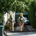 Firefighters enter a Balclutha property to assess the state of a solar system battery fire...
