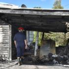 Fire and Emergency New Zealand investigator Mark Bredenbeck examines a home in Beechworth St...