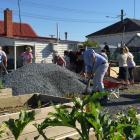 Telford staff take part in a working bee at the Balclutha Community Garden this morning. Photo:...