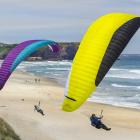 Roman Berner (left), of Switzerland, and Alex Tups, of Dunedin, model new paragliders as they fly...