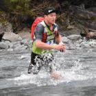 Dougal Allan crosses a stream during the mountain-running stage of the Longest Day at the...