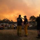 Fire fighters, medics and police plan fire control strategies for the evening near Minea in...