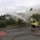 Firefighters use a hose to douse the blaze at a property in Oamaru this evening. Photo: Daniel...