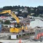 Demolished sections of the Fryatt St sheds are scooped into containers yesterday. PHOTO: PETER...