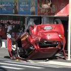 A car lies on its roof in Caversham yesterday, after being rear-ended by a van while stopped at a...