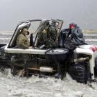 Four cold and wet passengers in a 4WD await rescue from the flooding Hopkins River on Saturday