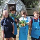 Proudly displaying produce harvested from the school garden for their Garden to Table session are...