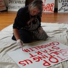 Gillian Bartrum paints a placard in preparation for tomorrow's Waitaki Community Hospital Action...
