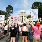 Protesters for women's rights hold a rally on the Alabama Capitol steps to protest a law week...
