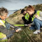 Scientist Hiltrun Ratz (left) and tour guides Julien Arriaga and Brooke Davies inspect a blue...
