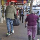 Weaving between pedestrians, a Lime scooter rider makes his way down George St using the footpath...