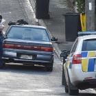 Police search a car parked in Craigleith St yesterday afternoon after reports of a group of men...