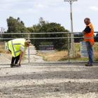 In January, a WorkSafe New Zealand official examines the Gore sewage treatment site gate through...