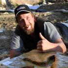 Ranfurly man Michael Johnston bonds yesterday with moa footprints he found in the Kyeburn River....