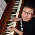 Young composer Nathanael Koh creates a masterpiece at his teacher’s piano. PHOTO: PETER MCINTOSH