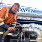 Wastech Services Dunedin employee Greg Hill prepares for another delivery of water yesterday....