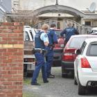 Armed police search a car in Clyde St, Dunedin, yesterday, part of a major national anti...
