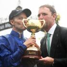 Rider Kerrin McEvoy and trainer Charlie Appleby pose with the cup after winning it with Cross...