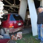 Ian Melton looks at the car which is still in his building in High St, Waimate, yesterday. PHOTO:...