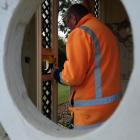 Downer staff member Garth Woodcock works to repair damage to the Elderslie summer house in the...