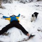 Maddie Hannah (13) and Sika play in the snow on Mt Cargill yesterday. PHOTO: AMBER HANNAH