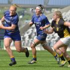 Otago Spirit centre Greer Muir tries to elude Wellington hooker Rosier Stirling while Spirit lock...