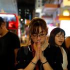 A woman pays her respects to protesters who were injured during clashes with the police, outside...