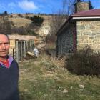 St Bathans property owner Tony Ward stands outside his historic cottage in the Central Otago town...