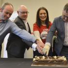 Cutting into a celebratory cake as the Dunedin City Council becomes an accredited living wage...