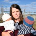 Katie Hill and her 3-month-old twins Chloe (left) and Zacon the boundary of her property near a...