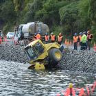 Fulton Hogan staff contemplate their next move after a roller ended up in Otago Harbour near the...