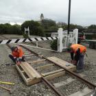 Waitaki District Council contractors construct a wooden footbridge over a section of the Oamaru...