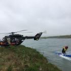 Rescue helicopter and search and rescue crew search the Waitaki River near Duntroon yesterday ...