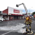 Firefighters attempt to access the second storey of Mosgiel's Postie building to get to the...