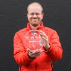 Dunedin electronic sports champion Simon Bishop (29) with a trophy he won racing digital cars in...