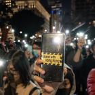 Pro-democracy supporters hold their phone flashlights at a rally to show support for students at...