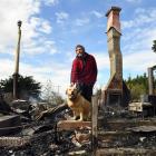 Malcolm Taylor and his dog Eva on the former front porch of his home, which was engulfed by fire...