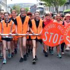 School traffic patrol team members are all smiles as they parade along George St dressed in...