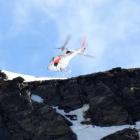 A helicopter flies over the site where two men died on the Remarkables yesterday. Photo: Guy...