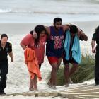 Lua Rasmussen (second left) helps Mosese Dolodolotawake (centre) ashore after the pair were among...