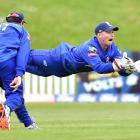 Auckland wicketkeeper Glenn Phillips catches out Otago batsman Neil Broom while watched by Martin...