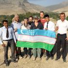 Local school teachers pose with the academics who worked on the site, and an Uzbek flag.
