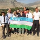 Local school teachers pose with the academics who worked on the site, and an Uzbek flag.
