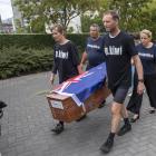 Camilla and Julian Cox and members of action group Patient Voice Aotearoa carry a coffin towards...