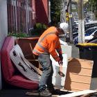 A contractor breaks up discarded furniture before removing it on Dundas St, in Dunedin’s student...