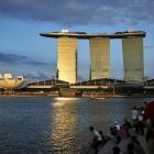 People sit on the waterfront as sunlight shines on the Marina Bay Sands resort in Singapore....