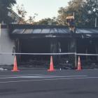 Police stand guard on Monday morning after a fire at Bristol Barbers on Wainoni Rd. Photo: Ian...