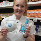 Pharmacist Alana Close, of Antidote Meridian, holds the store’s big sellers, a mask and hand...